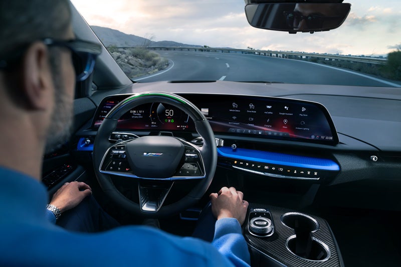 Front View of the 2026 OPTIQ-V Driving Through the Dusk Utilizing its Headlights | Lynn Layton Cadillac in Decatur AL